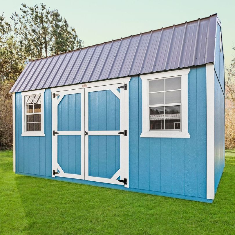 Superior Outdoor Centers  lofted barn A blue and white shed is sitting on top of a lush green lawn.