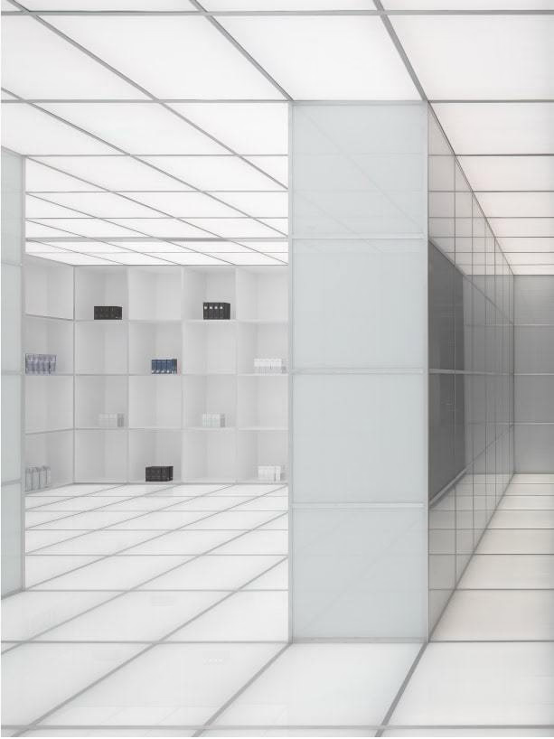 White, minimalist interior with square panels. A partially visible, dark rectangle is on a side wall — Tattoo Inc Studio In Broadbeach, QLD