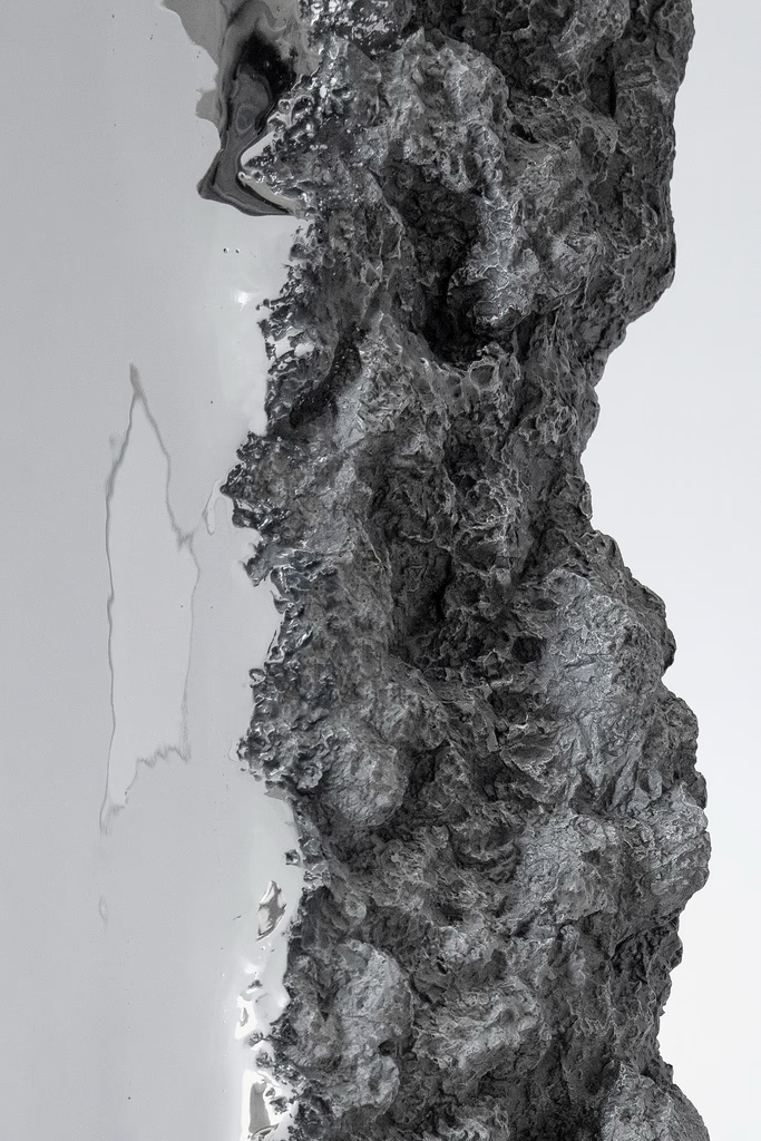 Close-up of a rough, textured, dark, vertical strip against a smooth, light background.