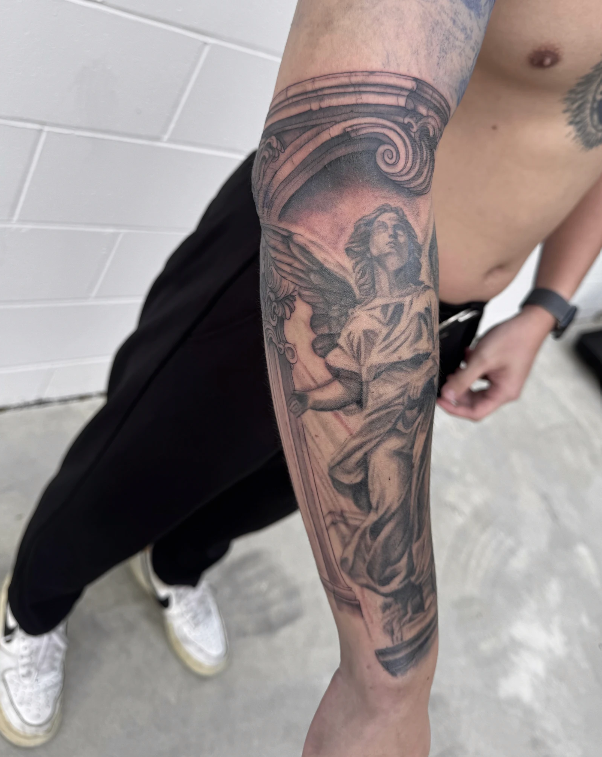 Tattoo Of An Angel On A Person's Forearm. Black And Grey Shading — Tattoo Inc Studio In Broadbeach, QLD