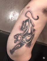 Black-and-gray lion and lioness tattoo on a bent arm, with flowing mane and bold shading