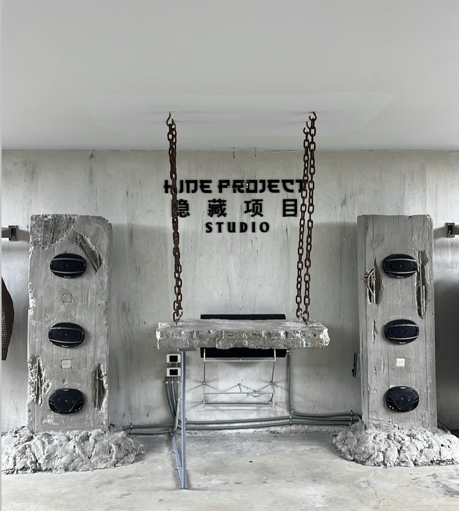 Concrete swing set in studio, with speakers on either side, 