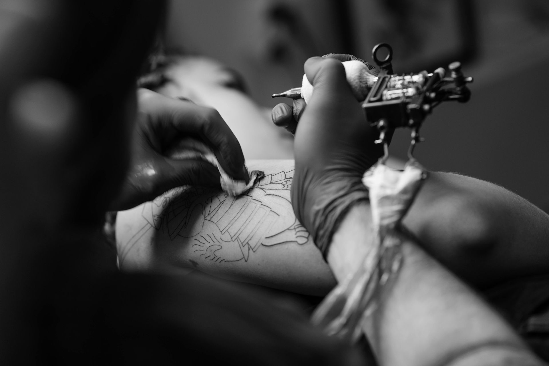 Tattoo Artist Applying Ink To A Person's Arm Using A Machine — Tattoo Inc Studio in Surfers Paradise, QLD