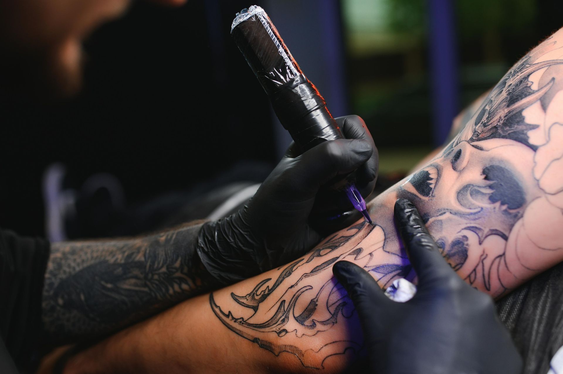 Tattoo Artist In Black Gloves, Using A Tattoo Gun To Ink A Detailed Design On A Client's Arm — Tattoo Inc Studio in Burleigh, QLD