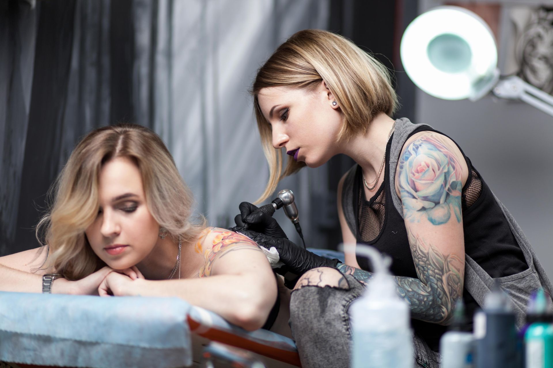 Woman Getting Tattooed On Her Back By A Tattoo Artist In A Studio; The Artist Has Tattoos  — Tattoo Inc Studio in Robina, QLD