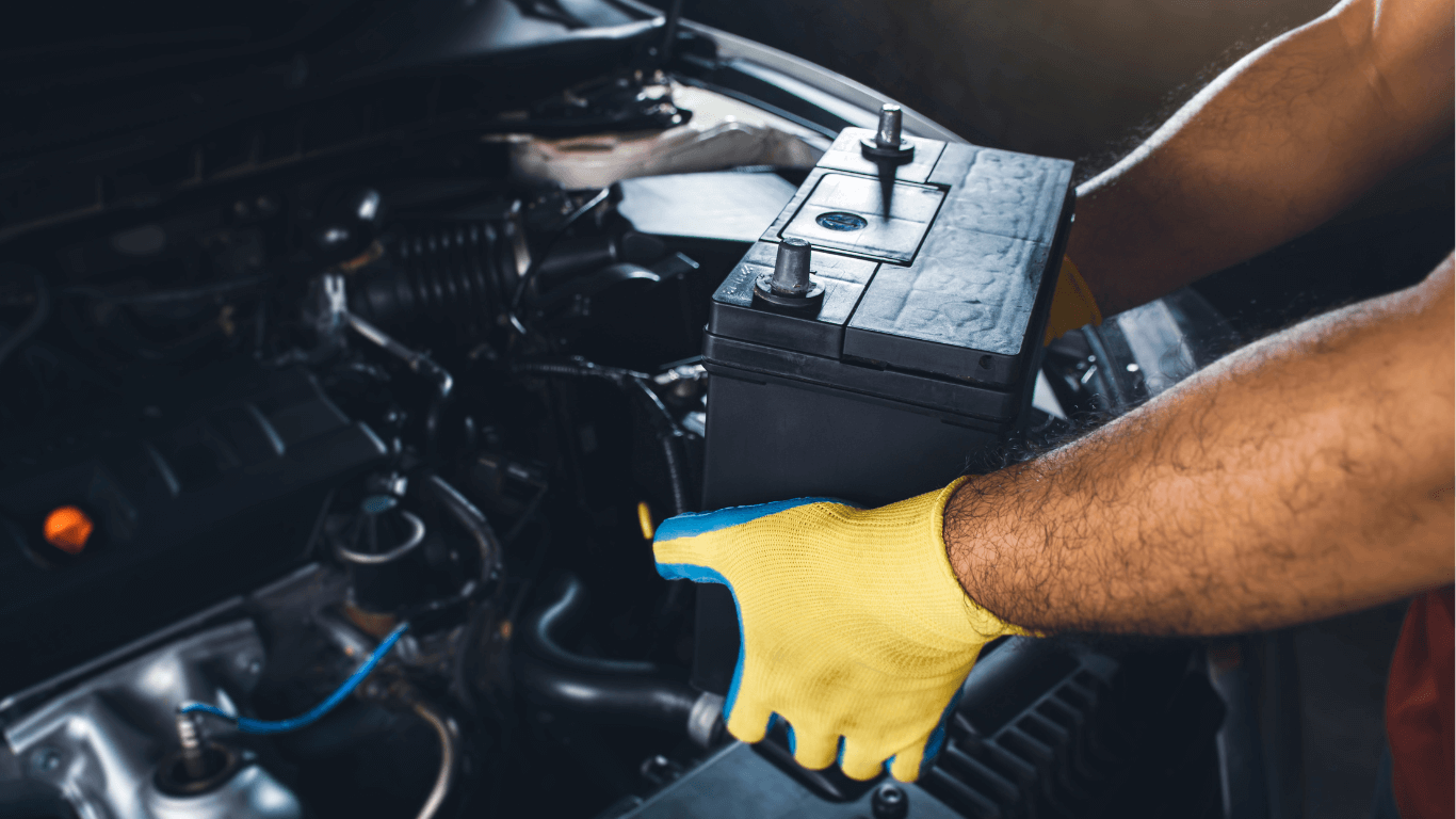 mechanic changing a battery in a car