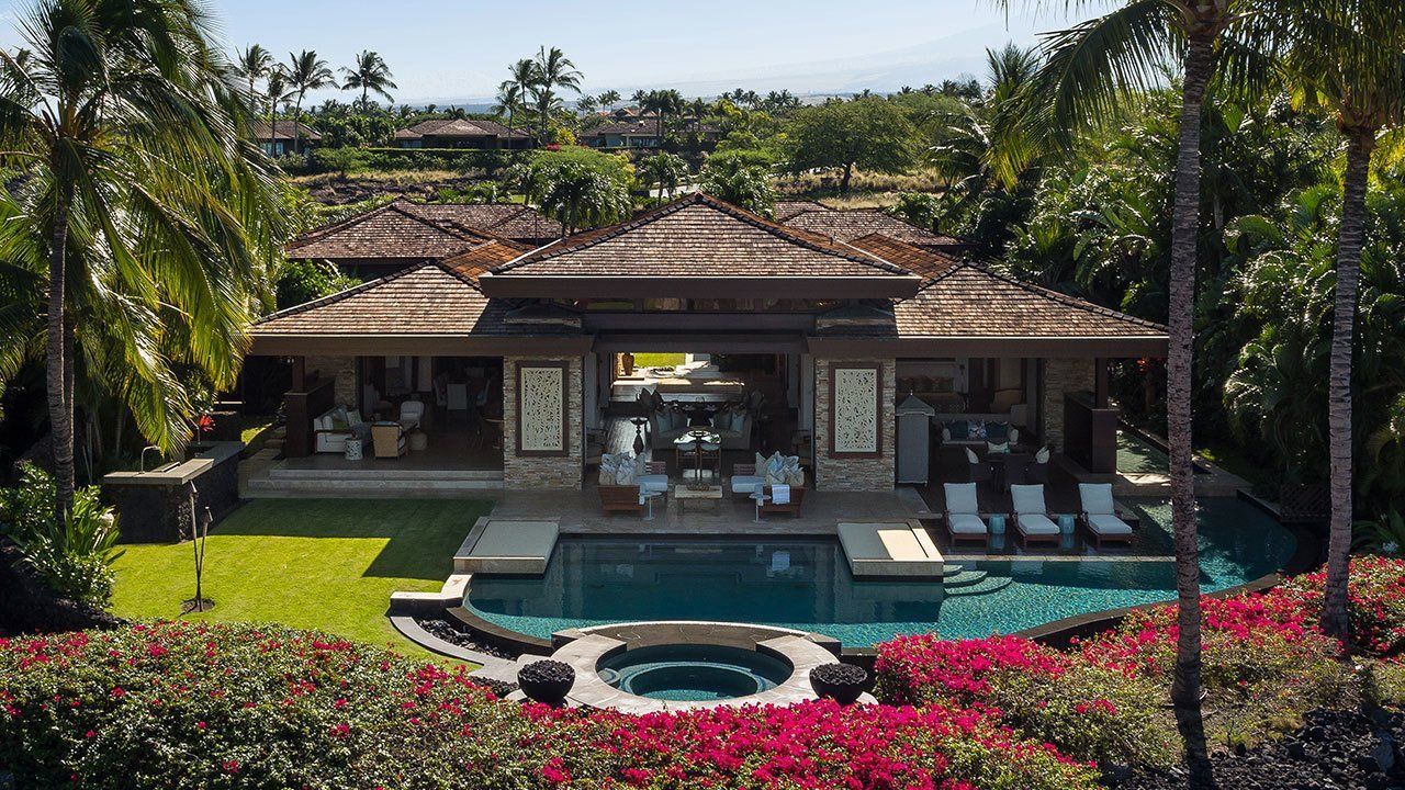 Luxury home with pool and tropical landscaping.