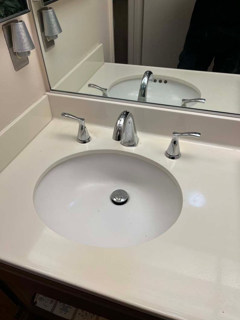 Red pump and gauges on a wall with plumbing.