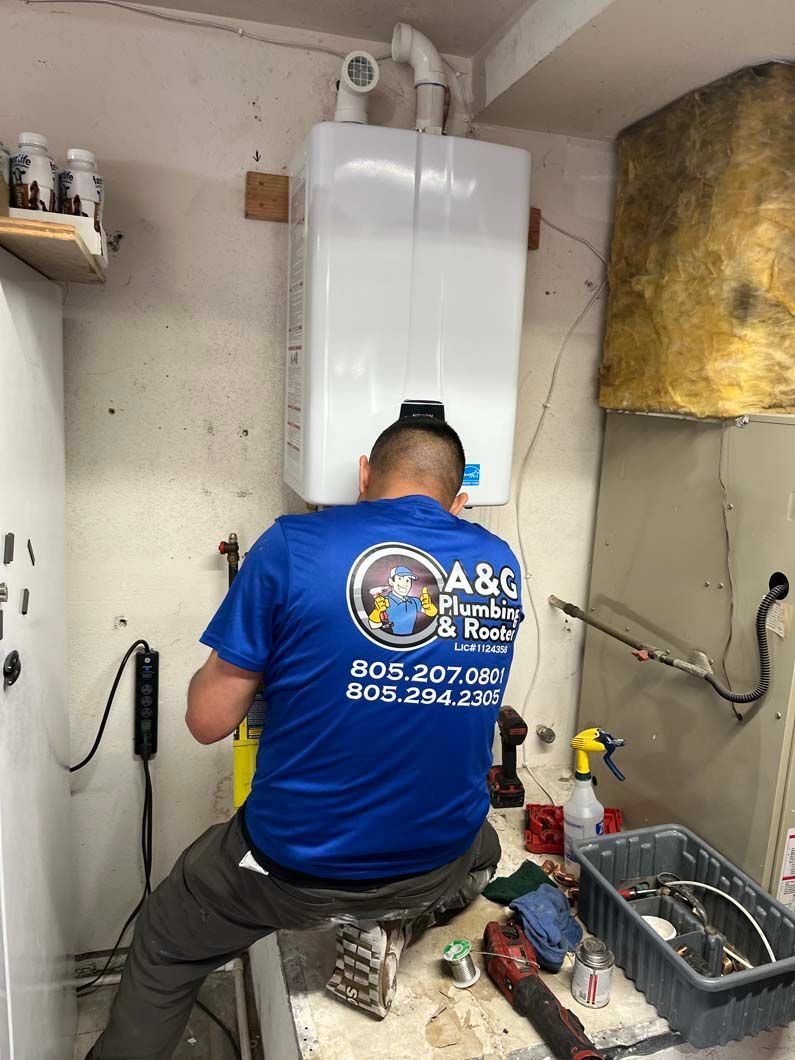 Man in safety glasses and gloves repairing a white water heater.
