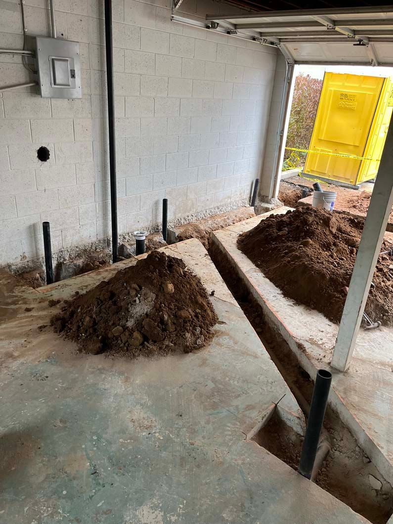 White tankless water heater mounted on a dark gray exterior wall.