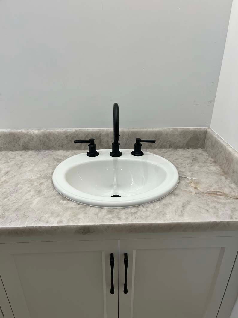 Bathroom with white walls, water heater, washing machine, and sink.