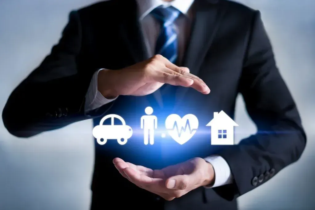 Person in suit holding illuminated icons of a car, person, heartbeat, and house.