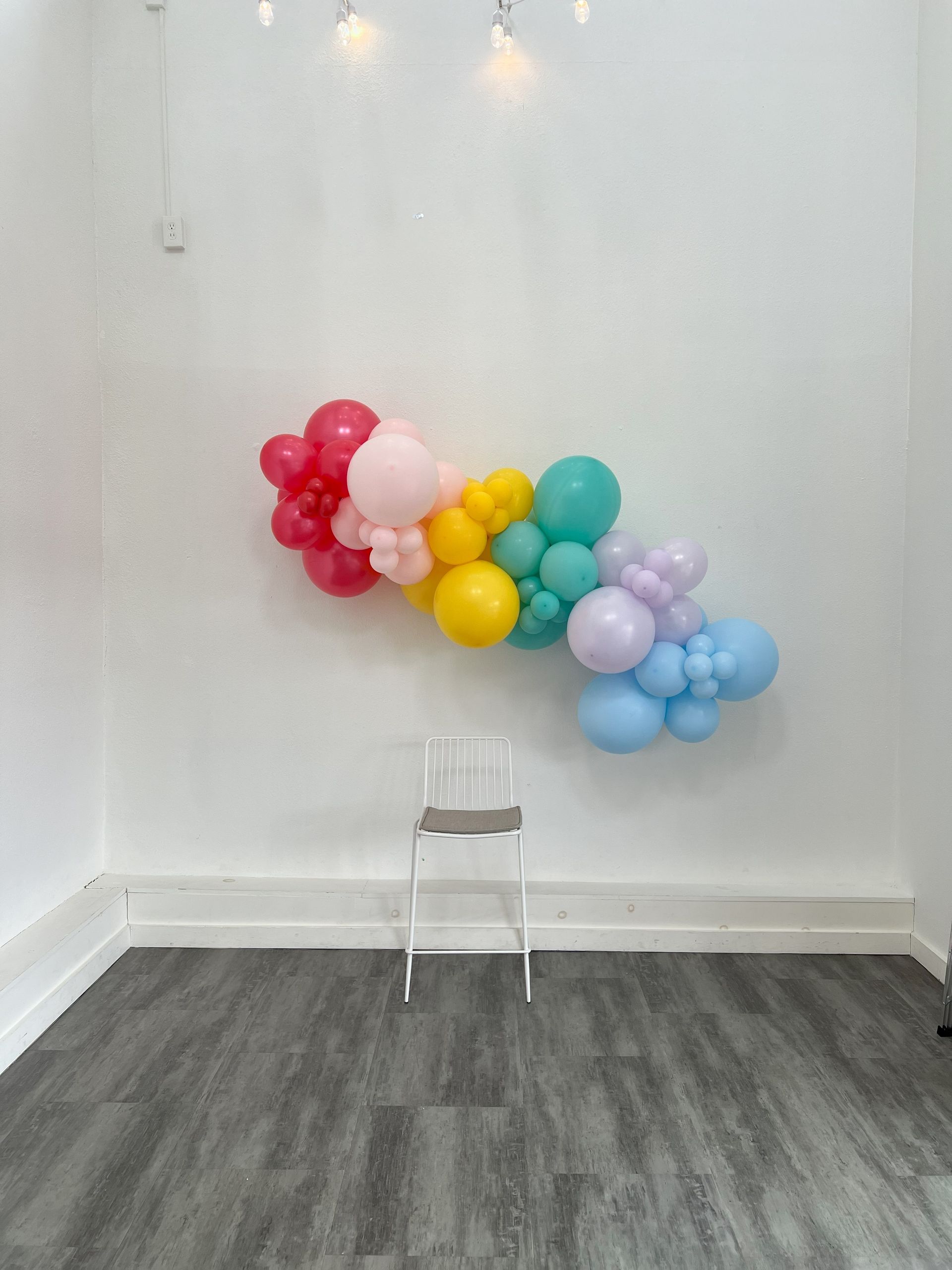 a room with a chair and a bunch of balloons on the wall