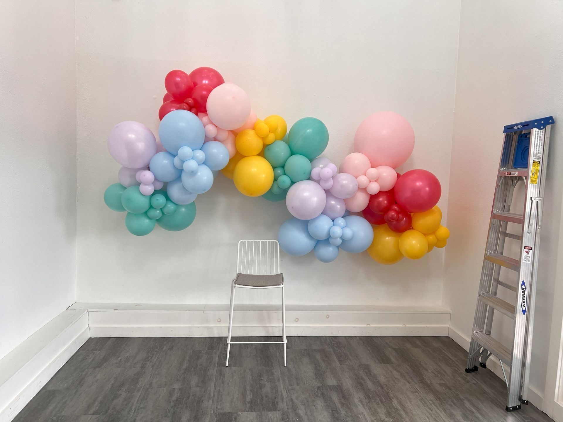 a room filled with balloons and a ladder