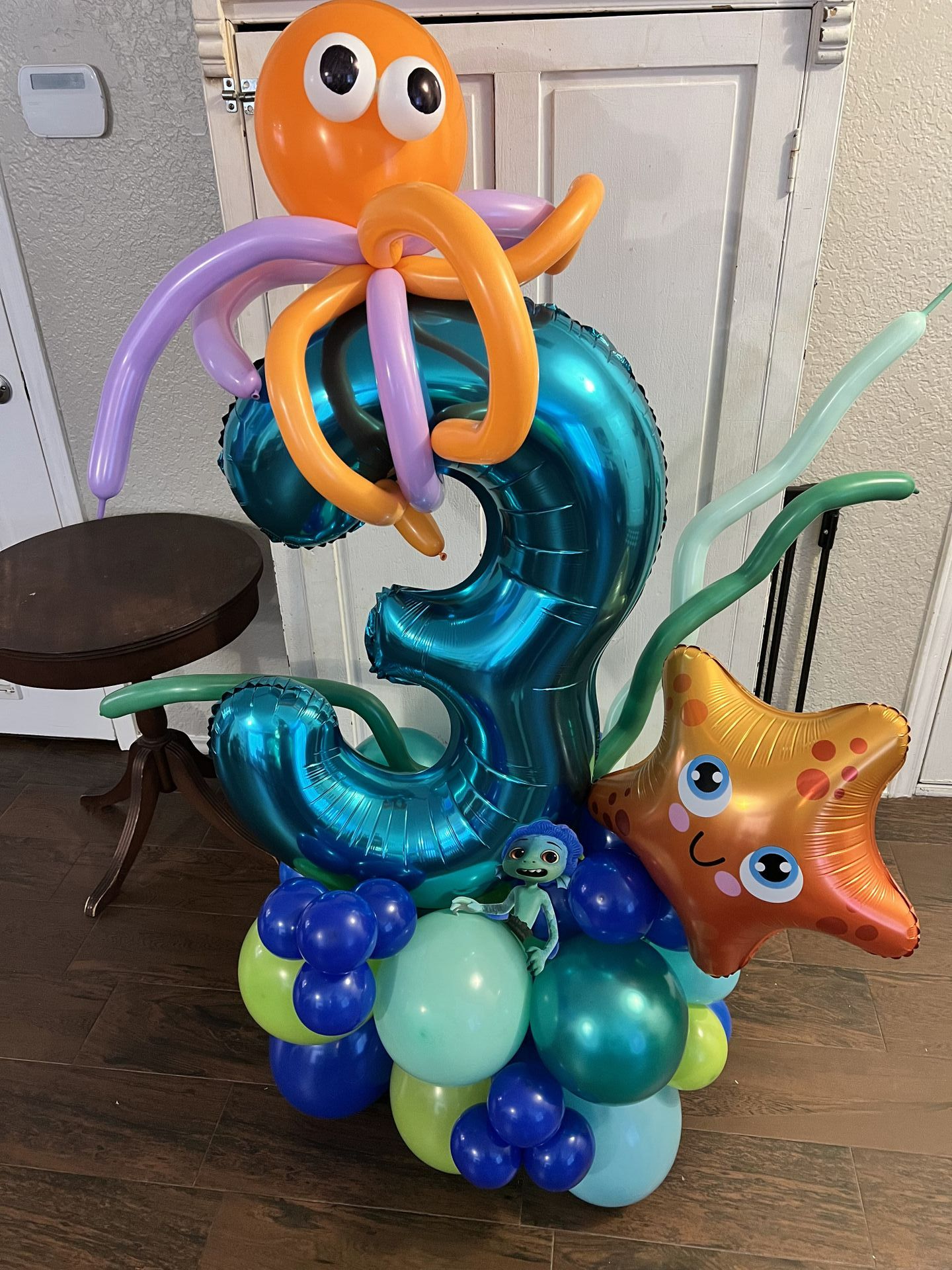 a bunch of balloons are sitting on top of each other on a table