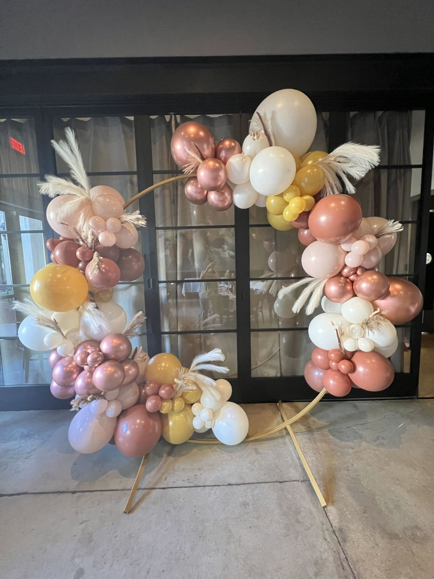 a bunch of balloons are sitting on the ground in front of a window