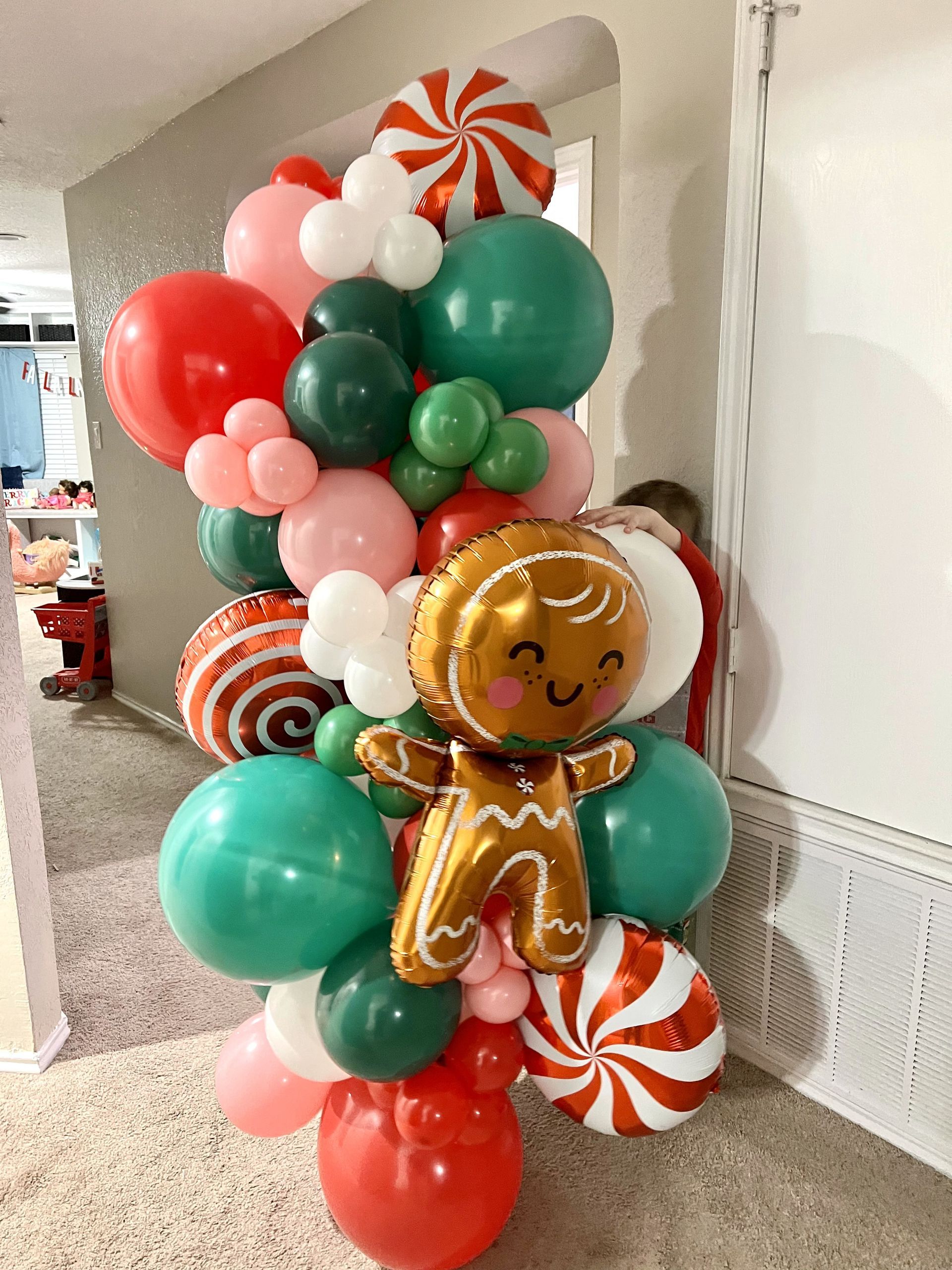 there is a gingerbread man balloon in the middle of a bunch of balloons