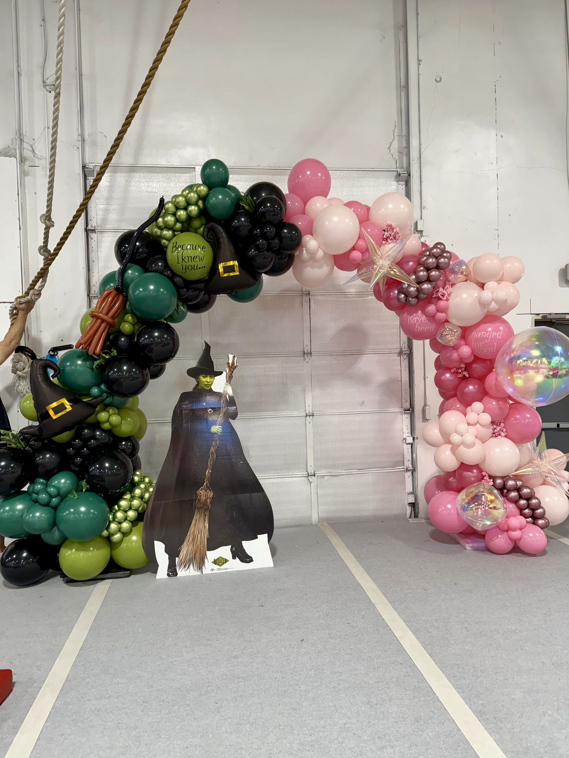 A balloon arch with a picture of a witch on it