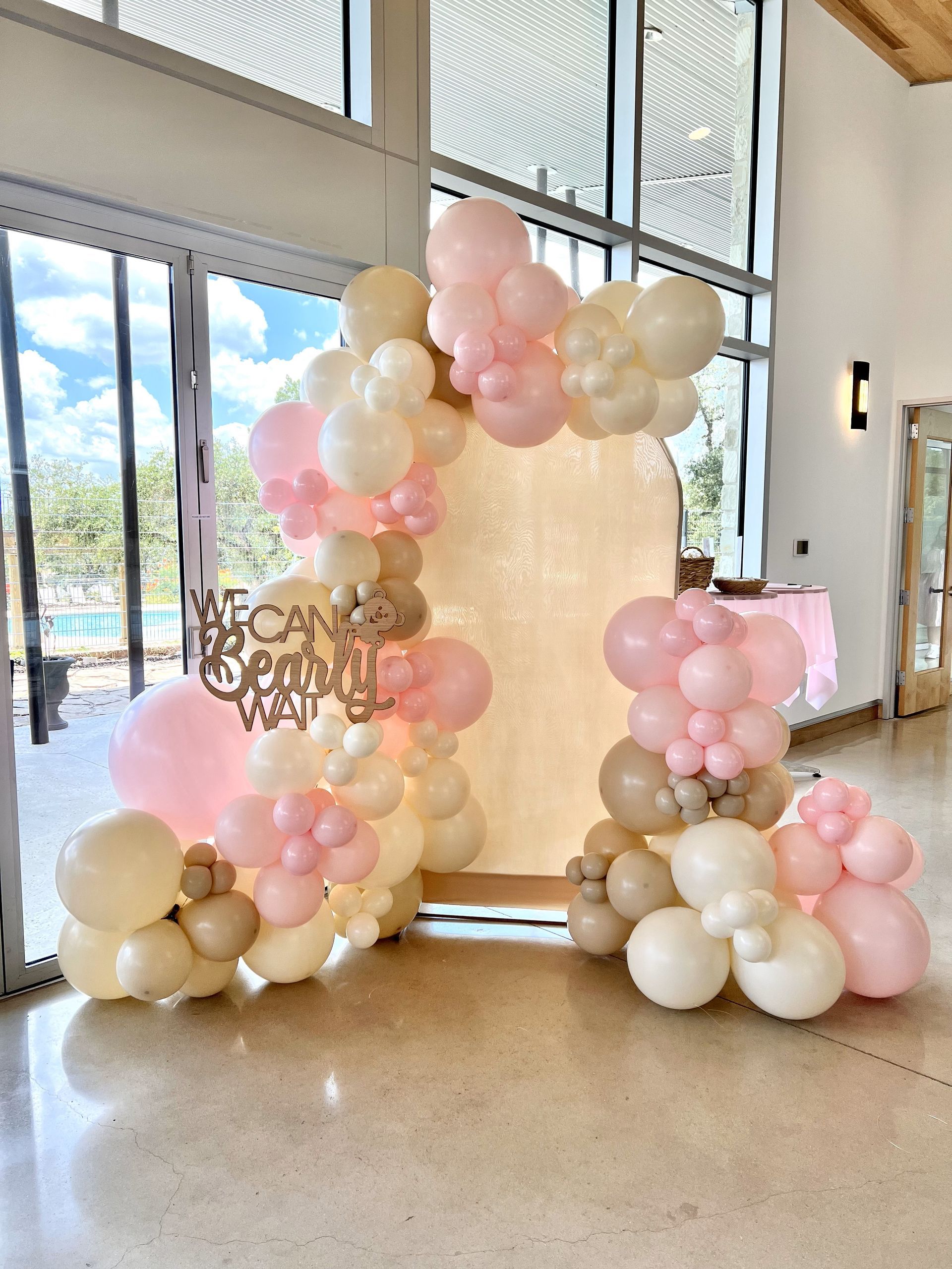 a room filled with lots of pink and white balloons
