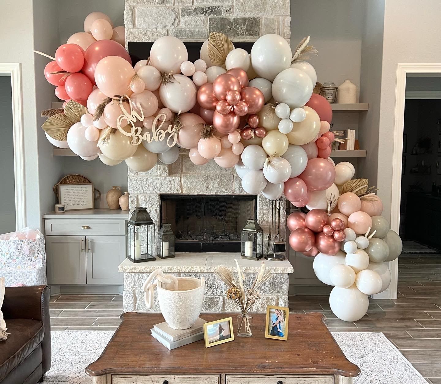 A living room with a fireplace decorated with balloons and a coffee table.