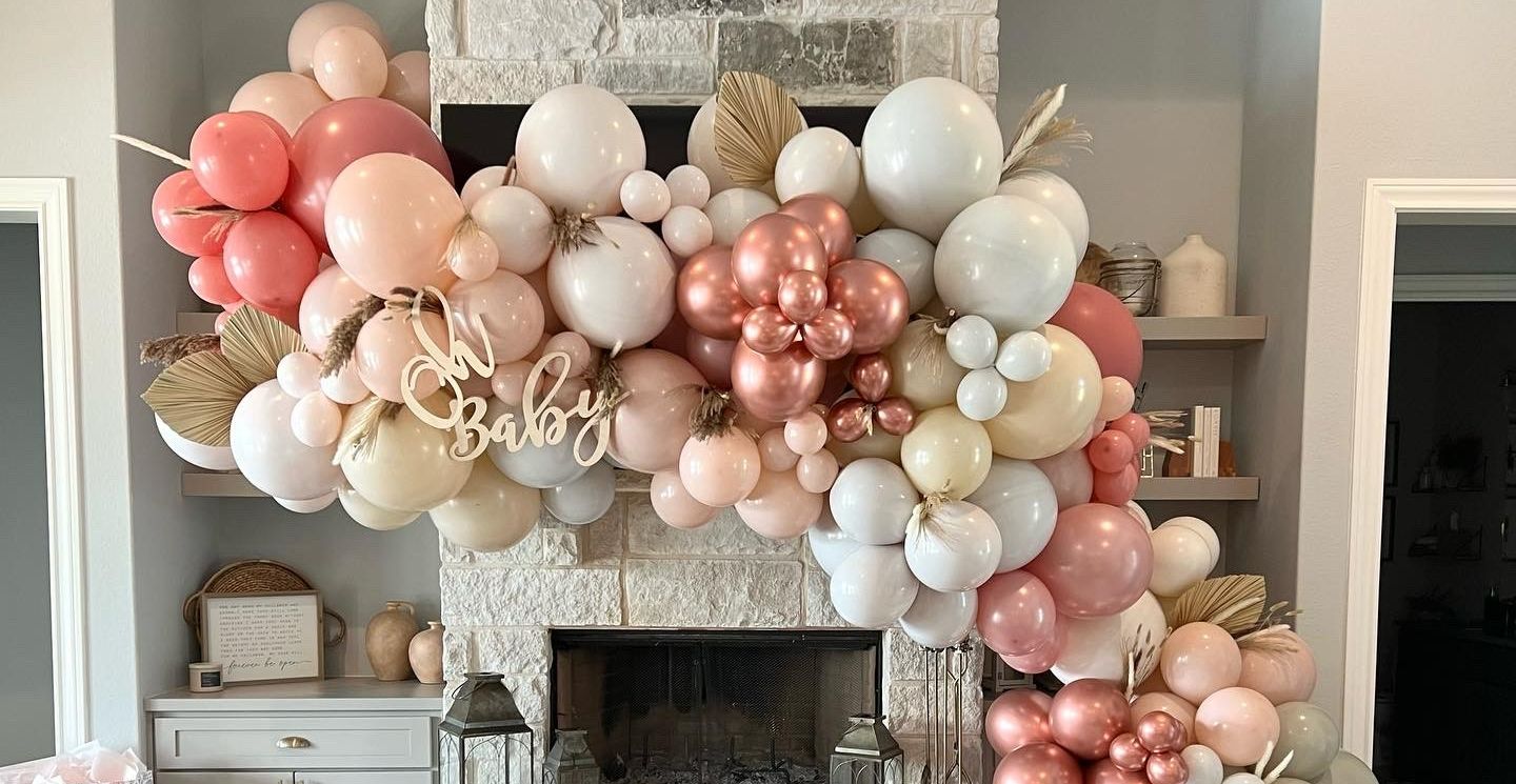 a fireplace decorated with balloons for a baby shower