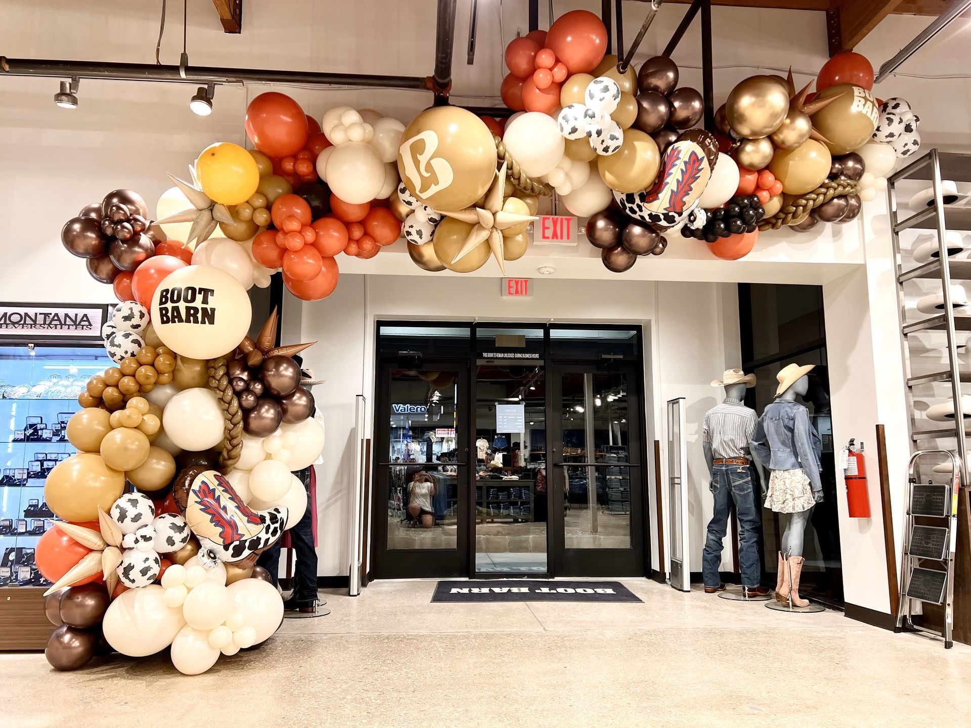 A bunch of balloons are hanging from the ceiling in a room.