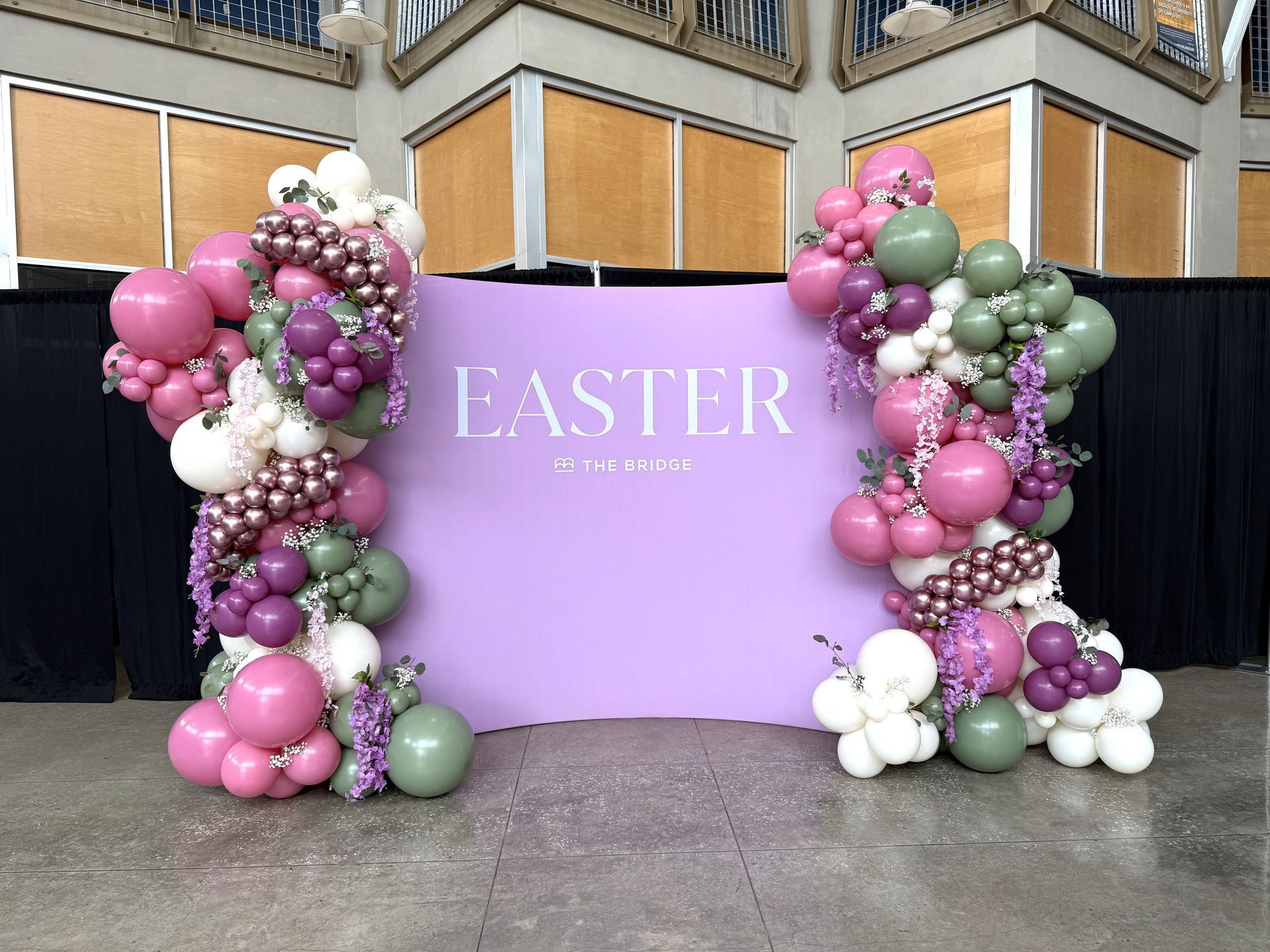 A purple wall with balloons and the word easter on it