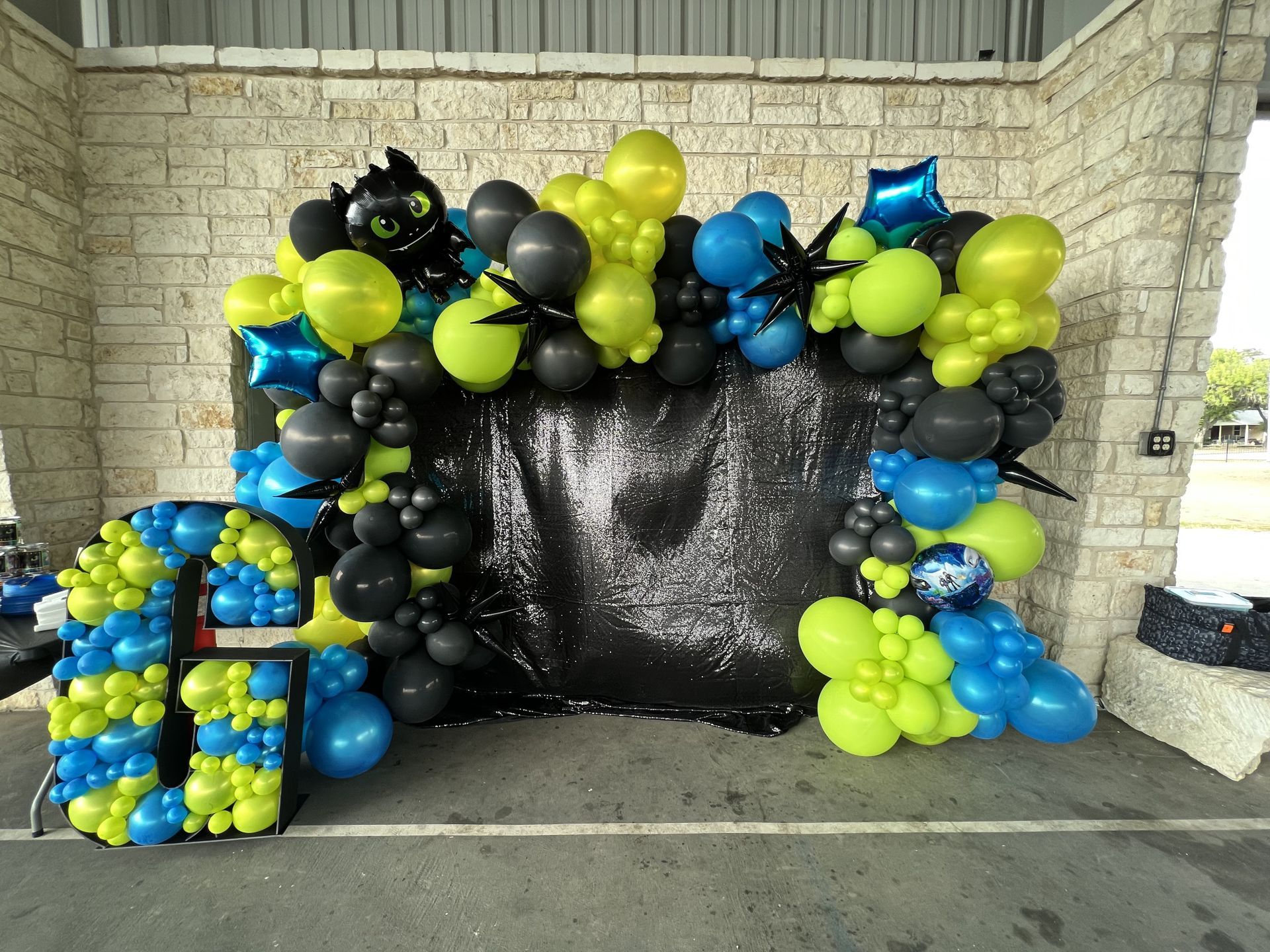 a bunch of balloons are sitting in front of a brick wall