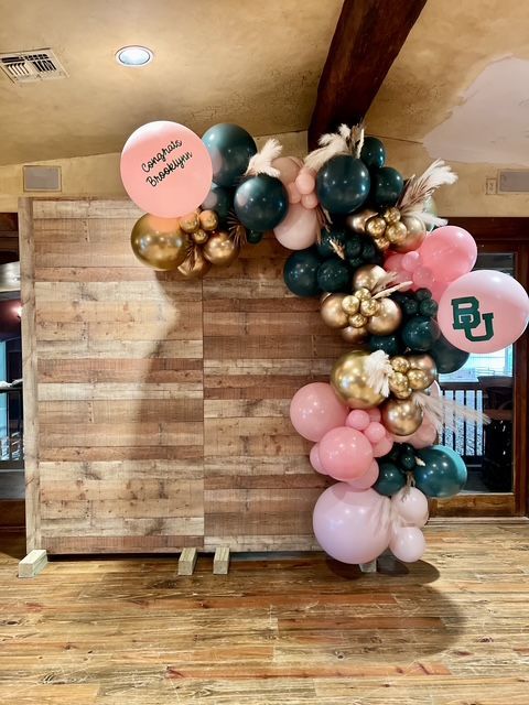 A wooden wall with balloons on it and a wooden floor.