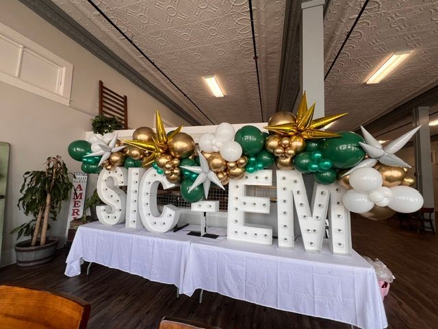 A table with balloons and letters that say sic em