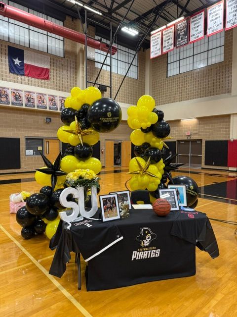 A table with balloons and a sign that says su on it