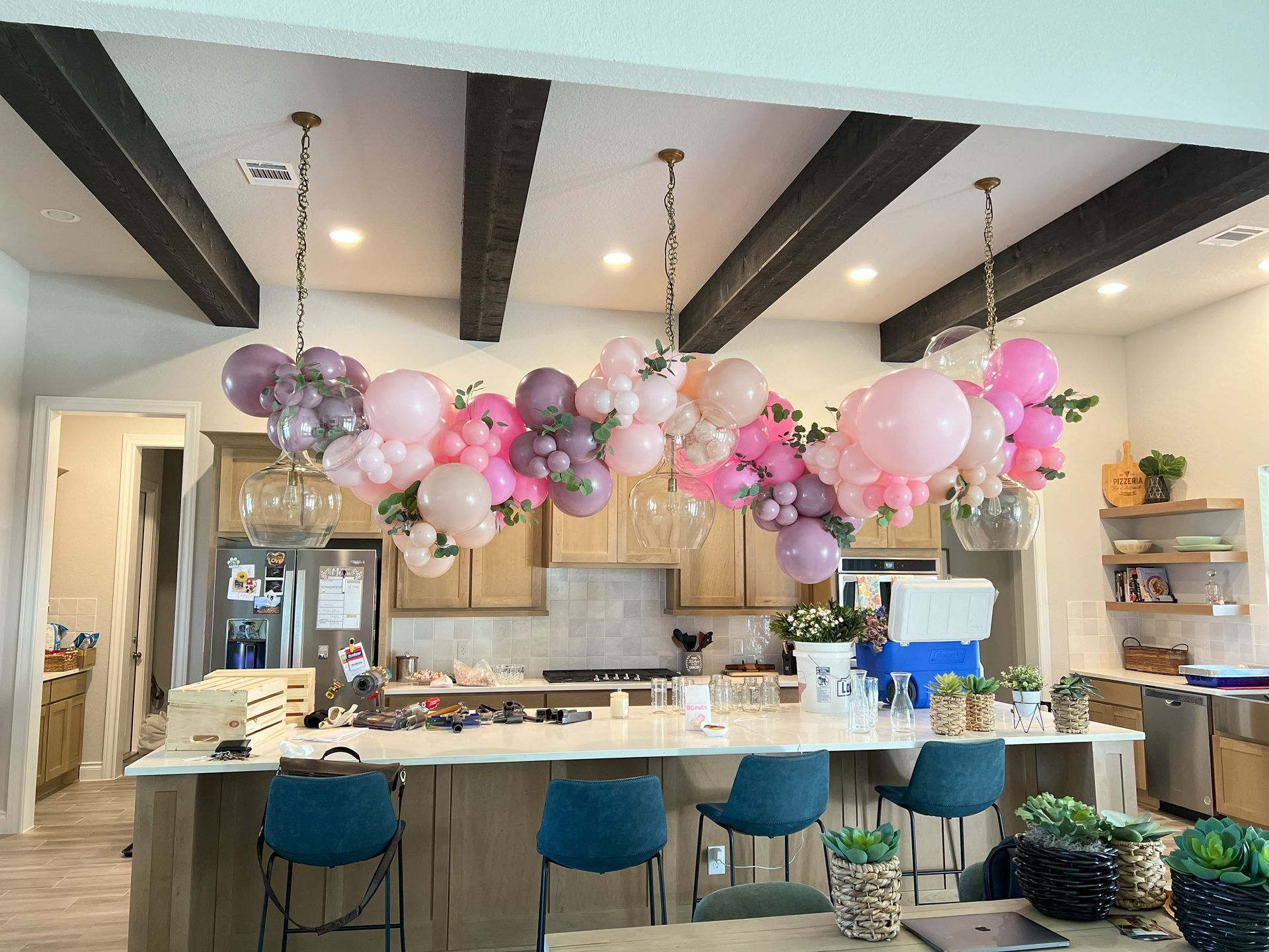 a kitchen with pink and purple balloons hanging from the ceiling