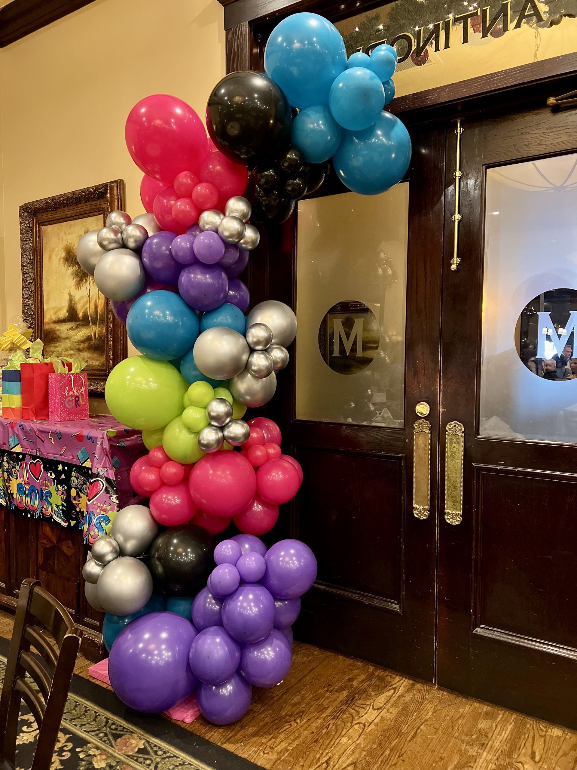 a bunch of colorful balloons are sitting in front of a door