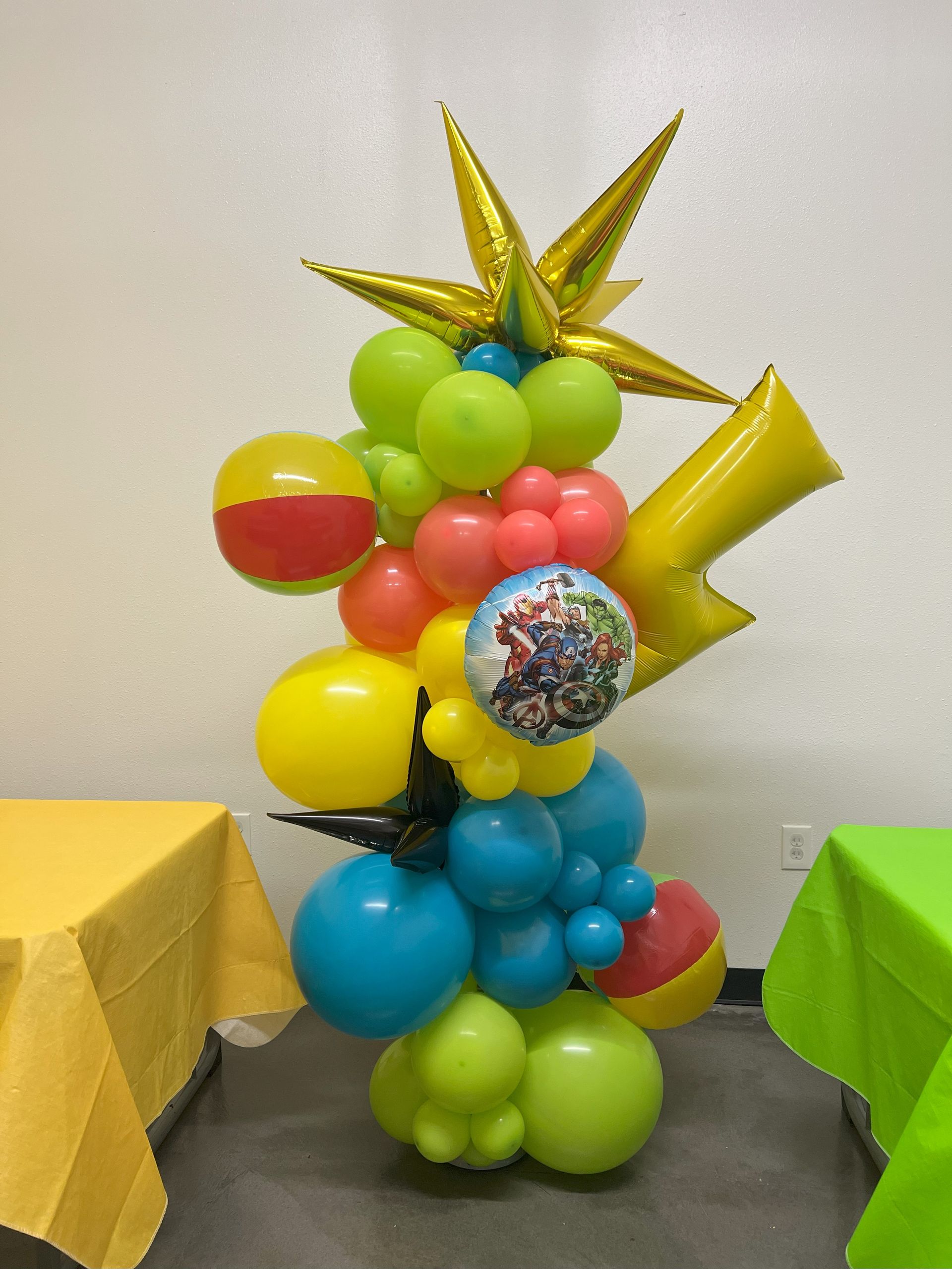 a bunch of colorful balloons are stacked on top of each other