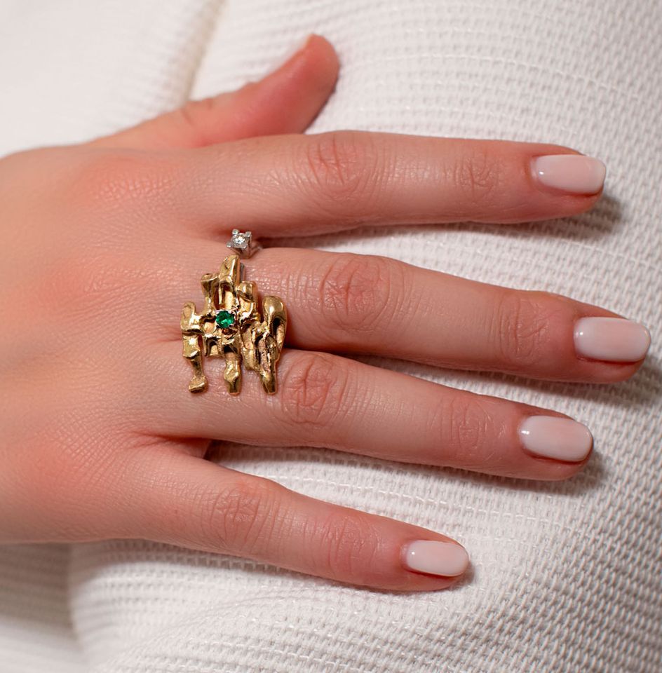 Gold, emerald and diamond ring worn