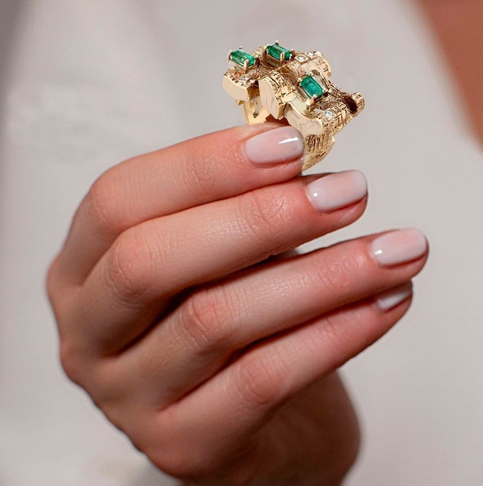 gold diamond and emerald ring on hand