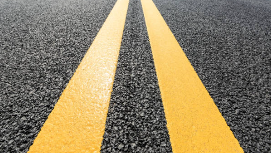 Yellow line striping on an asphalt driveway