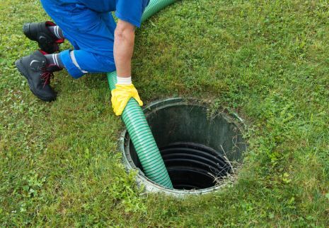 Experienced technician performing trusted septic tank repair service at residential property
