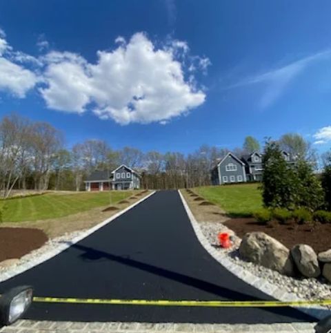 Asphalt paving crew laying smooth blacktop surface for road and driveway improvement