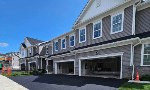Smooth residential asphalt driveway freshly paved in front of a suburban home