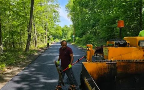 Residential asphalt driveway paving with smooth blacktop finish in front of a suburban home
