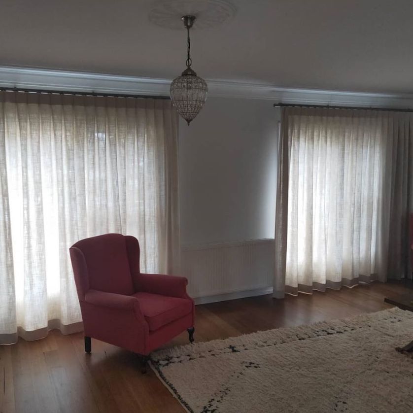 Red single couch with carpet on the floor - Curtains in Welby, NSW