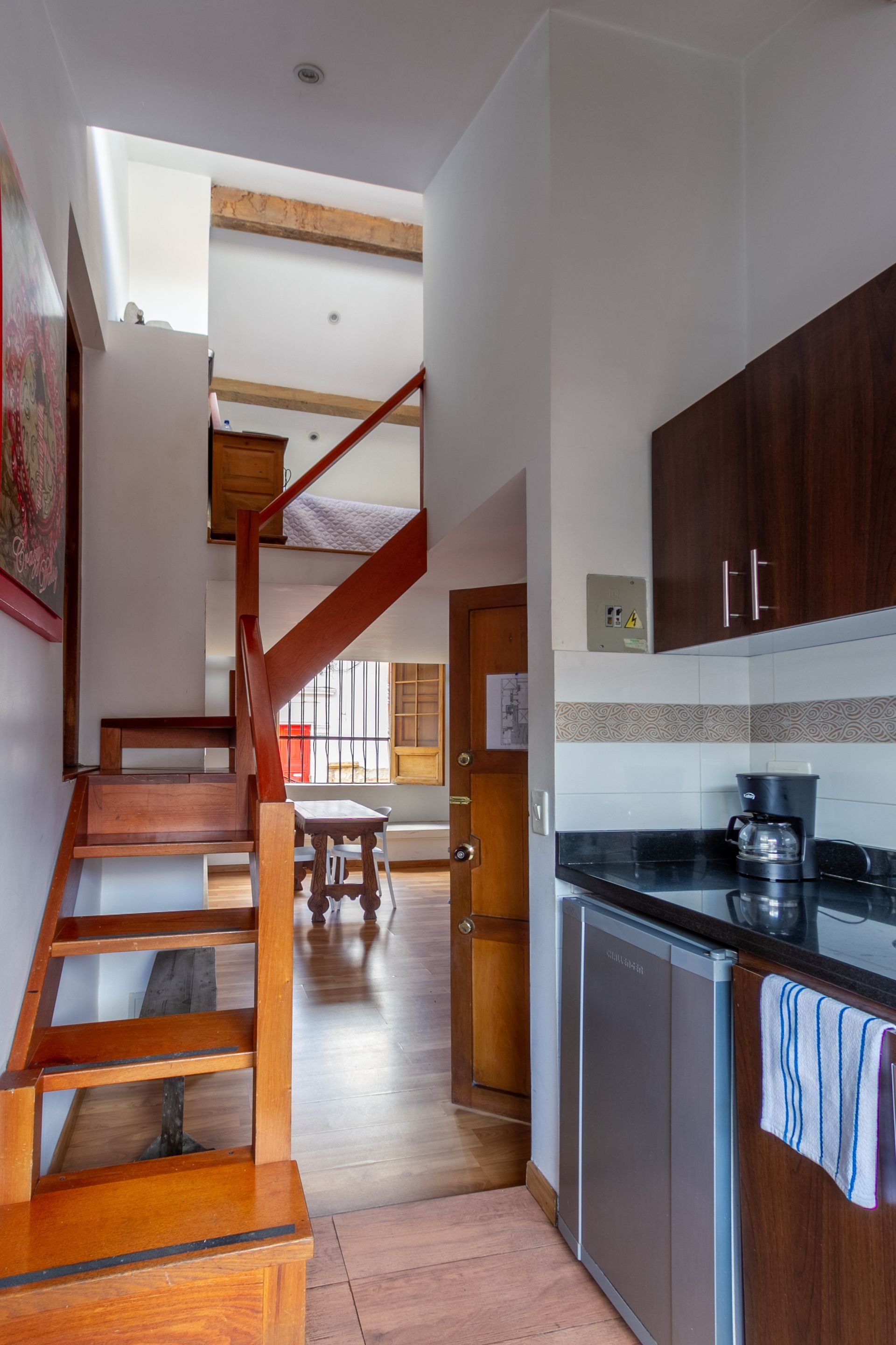 A kitchen with a staircase leading up to the second floor
