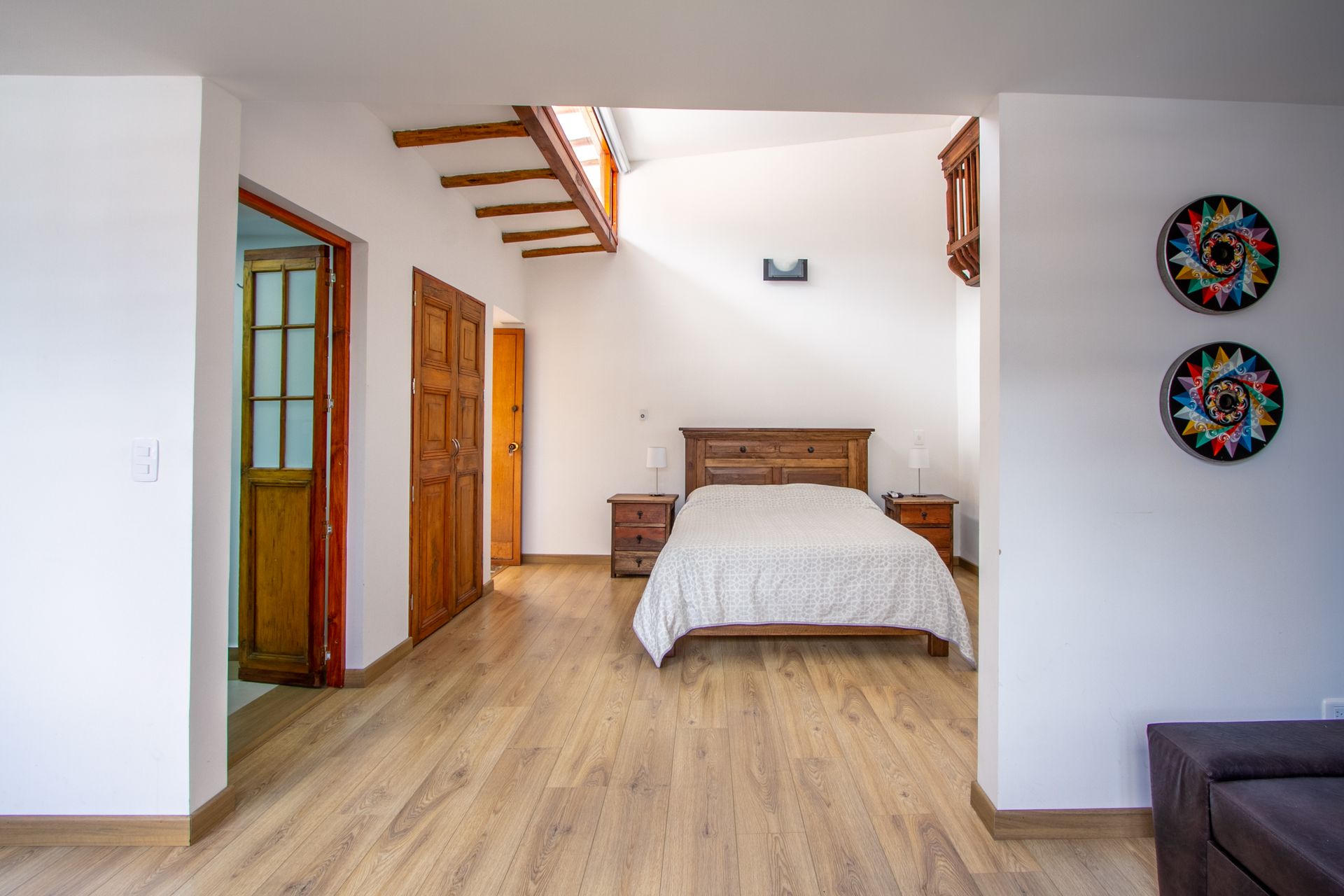 A bedroom with a bed and two plates on the wall.