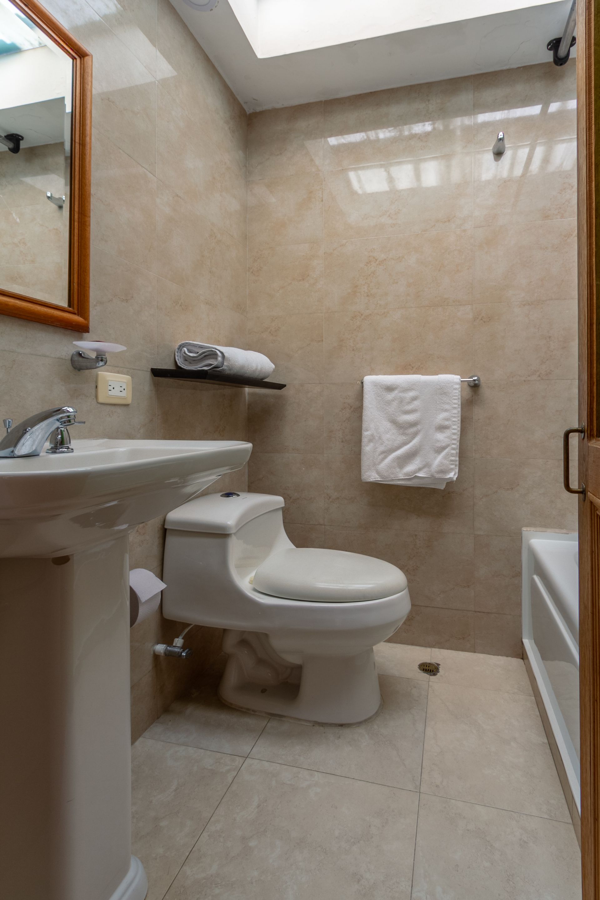A bathroom with a toilet , sink and bathtub.