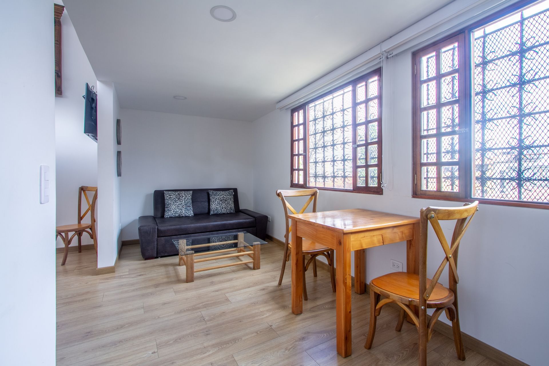 A living room with a couch , table and chairs.