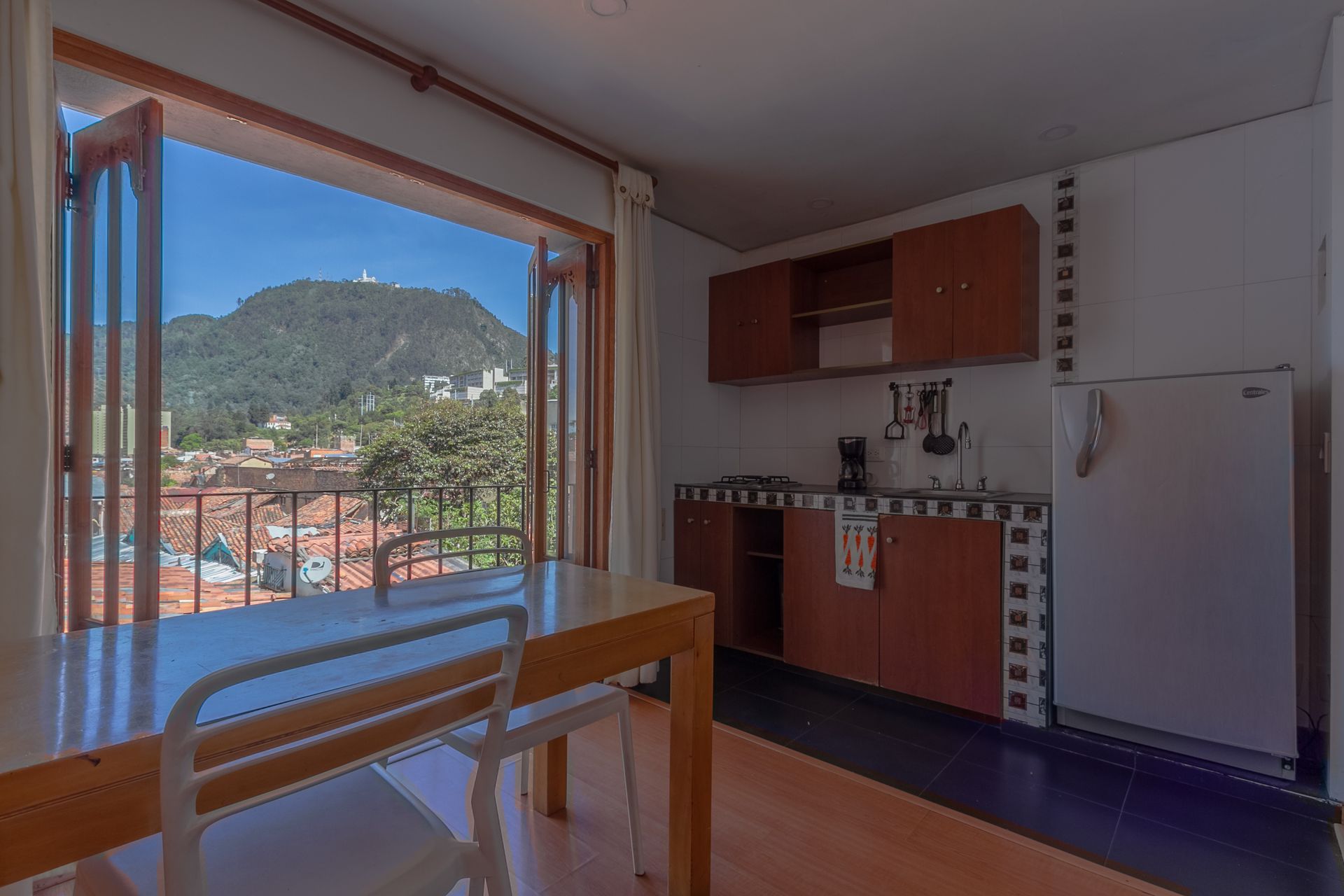 A kitchen with a table and chairs and a view of a mountain.