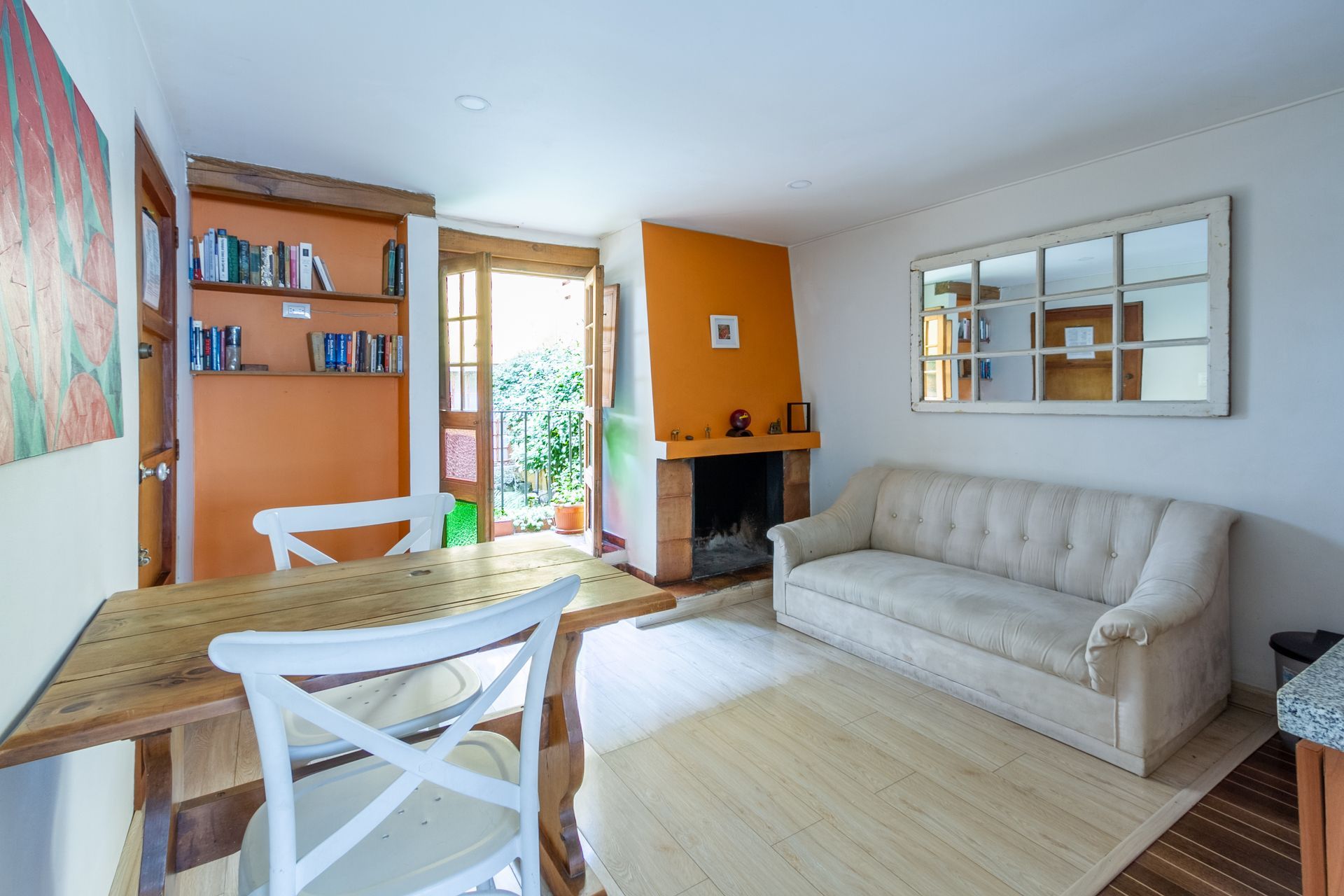 A living room with a couch , table , chairs and fireplace.