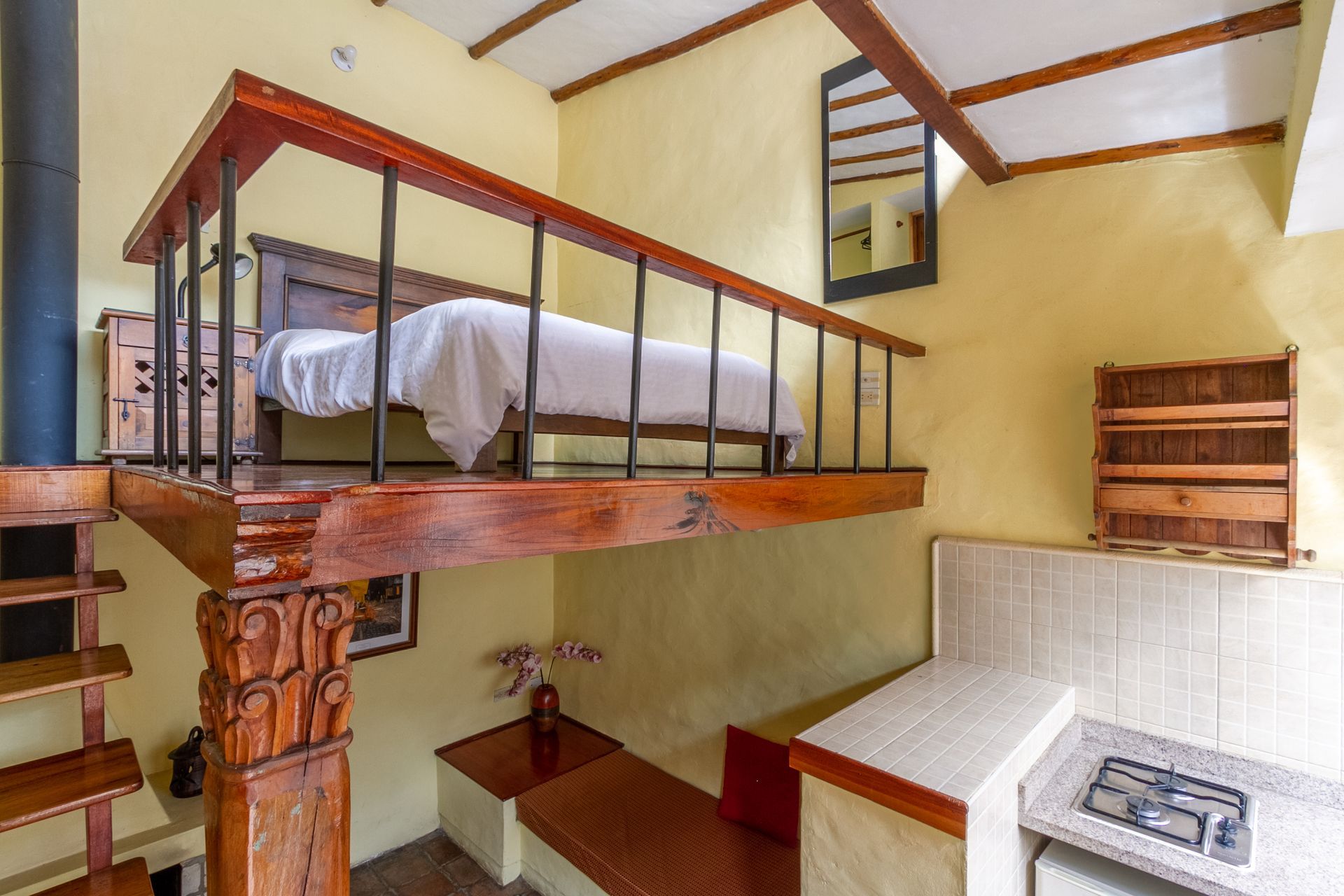 A bedroom with a bunk bed and a kitchen with a stove.