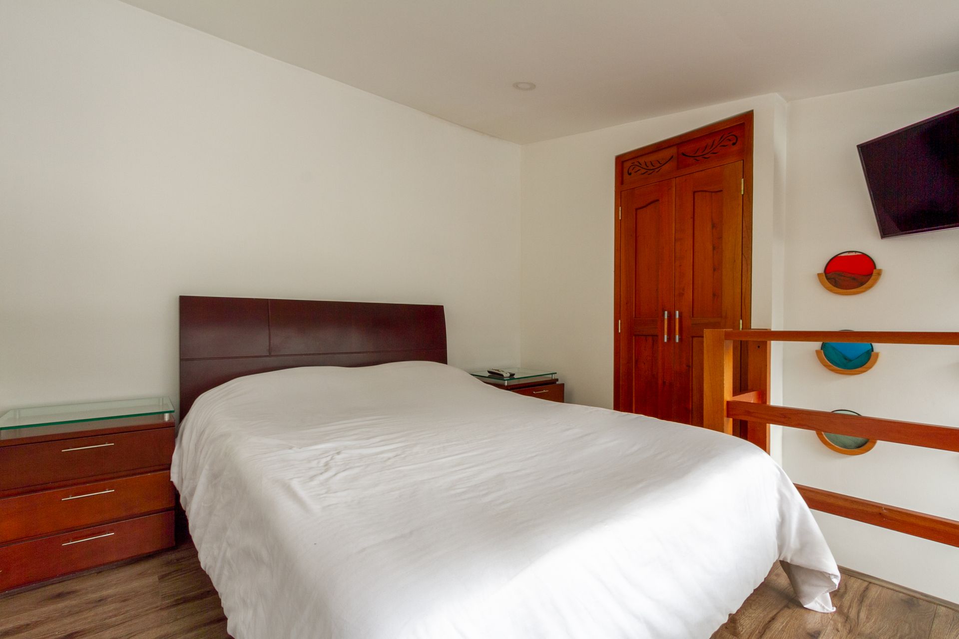 A bedroom with a bed , dresser , and television.